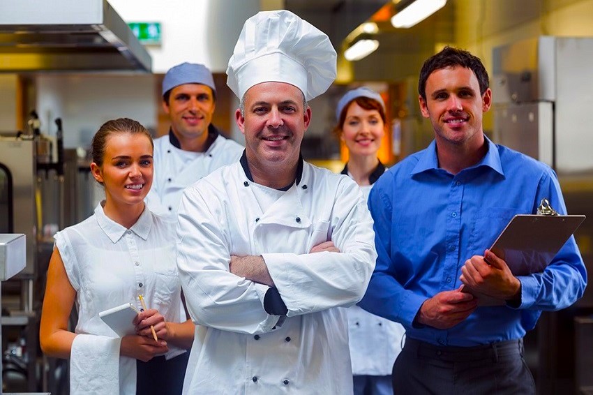 a chef and his team in a kitchen
